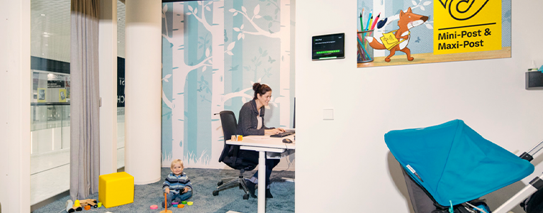 Mutter mit Kleindkind sitzt im Büro